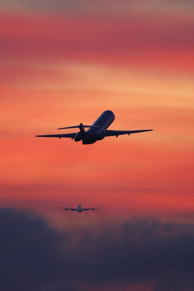 Two airplanes flying away after take off in the sunset.jpg